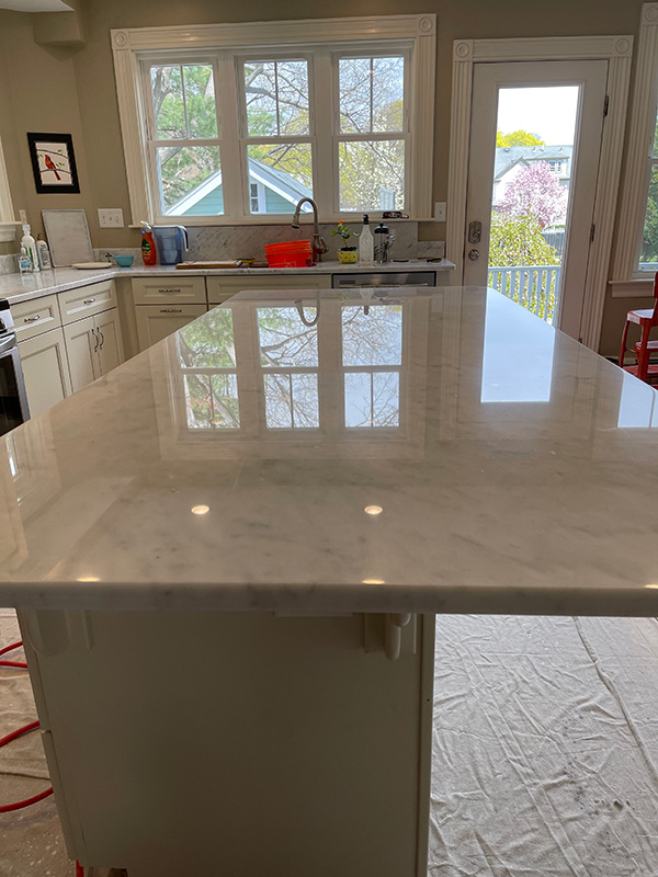 a marble countertop or surface being restored by a worker